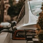 Carro elétrico branco a carregar numa rua da cidade