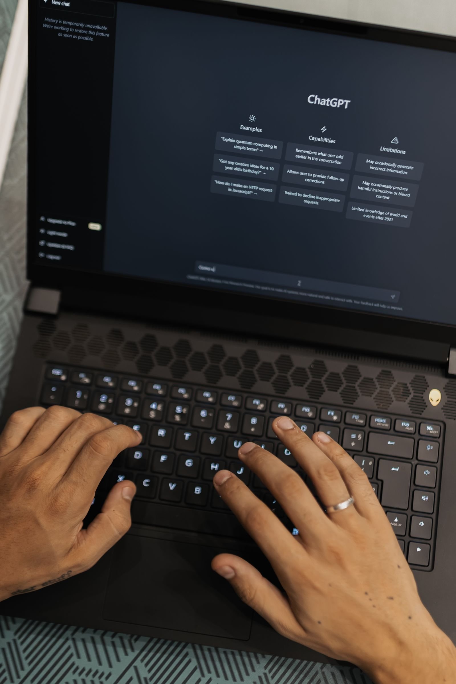Mãos a escrever num portátil com uma interface de chatbot de IA no ecrã