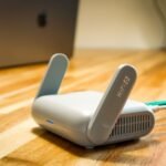 Router Wi-Fi 6 pousado numa secretaria de madeira