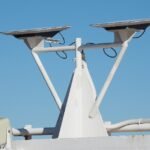 Duas antenas Starlink montadas num mastro, sob um céu azul