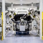 Braços robóticos a montar um carro numa fábrica moderna